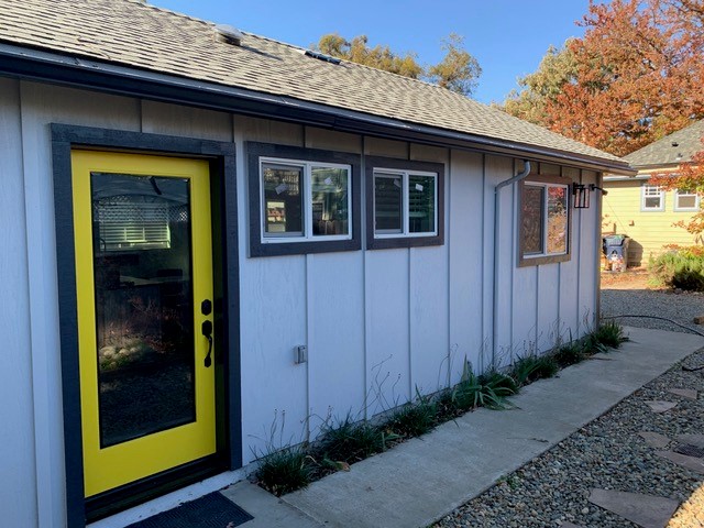 grey and black accessory dwelling unit with a yellow trimmed door.
