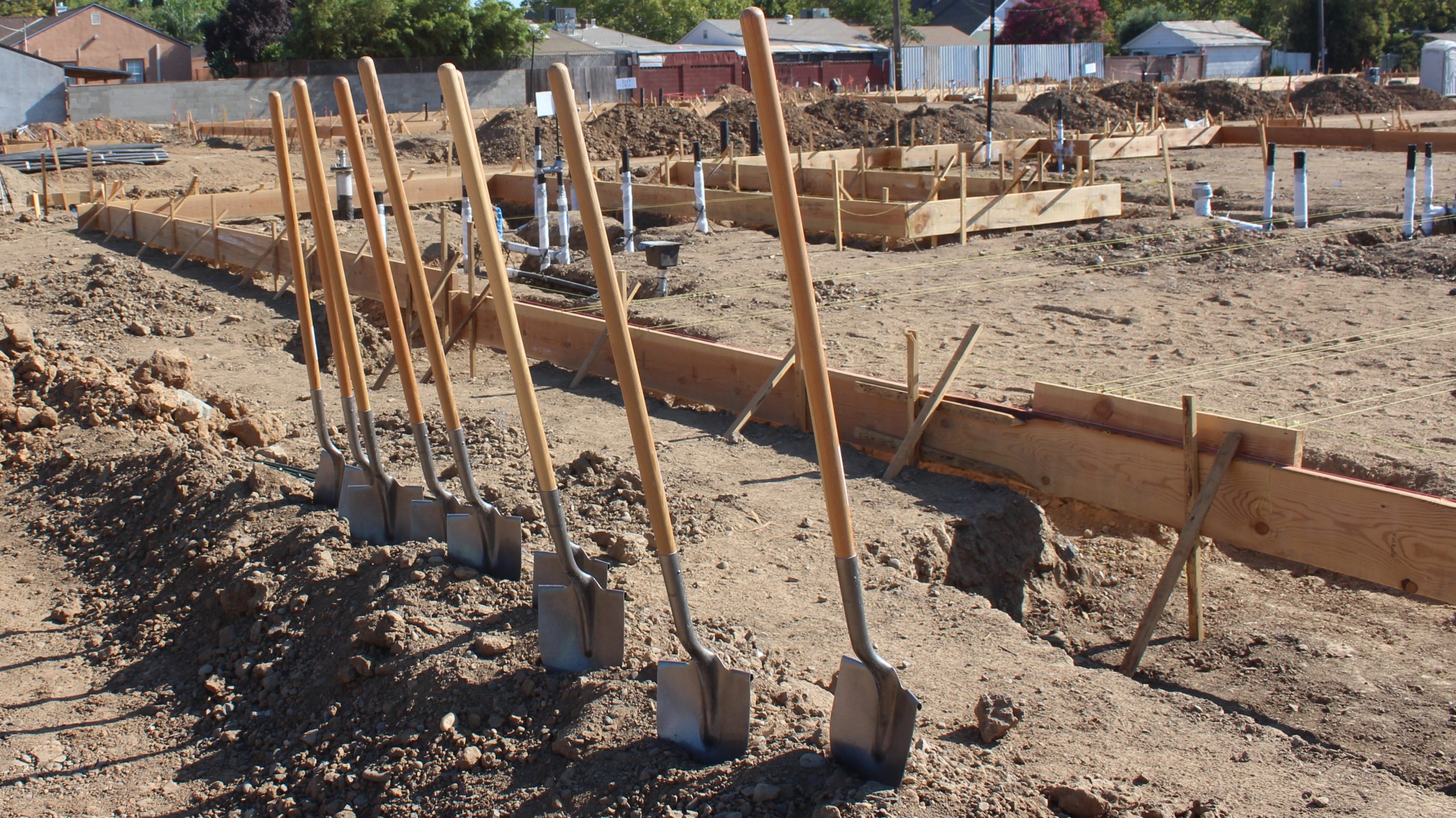 six shovels in the dirt at a construction site
